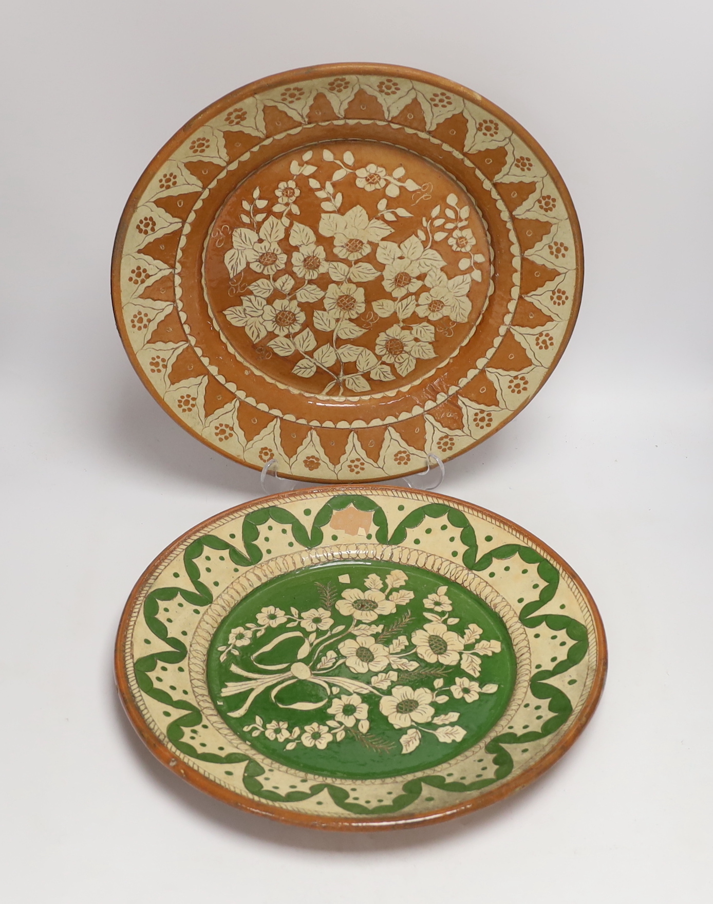 Two Portuguese glazed and incised pottery chargers, 36cm diameter